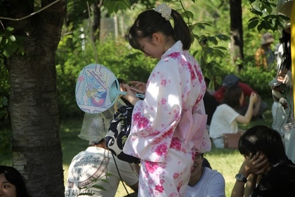 うちわを持つ白い浴衣の女性