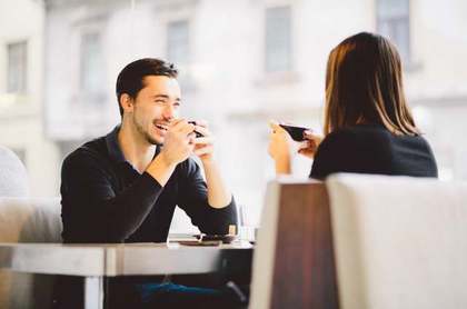 カップを持って会話をする男女